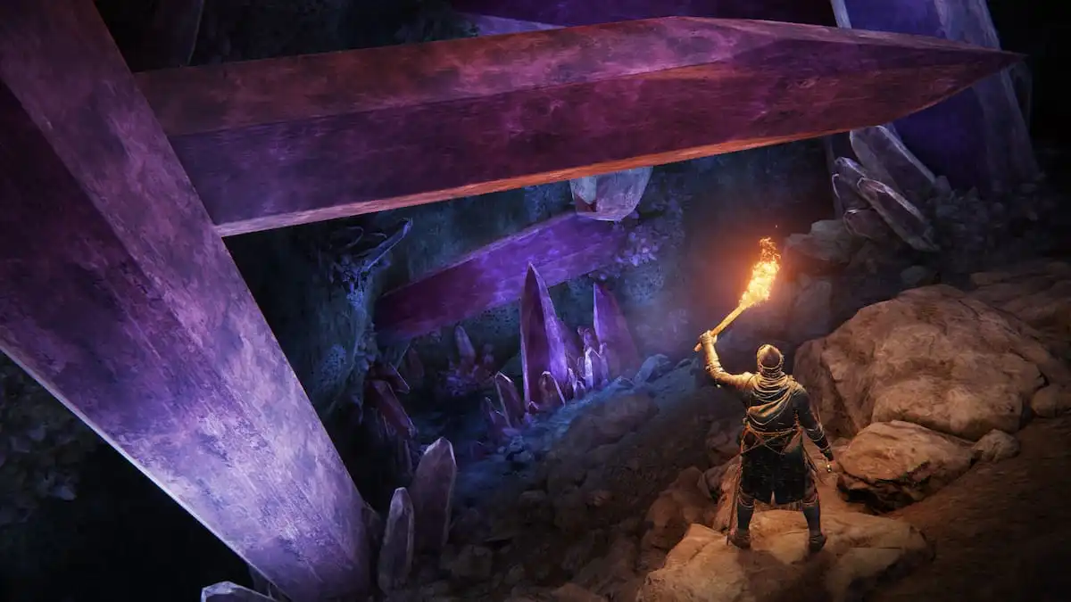 Elden Ring screenshot showcasing the player with a torch inside a cave with large pink crystals